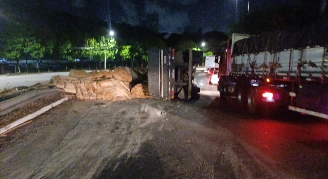 Caminhão carregado de madeira tomba na BR-101, em Paulista